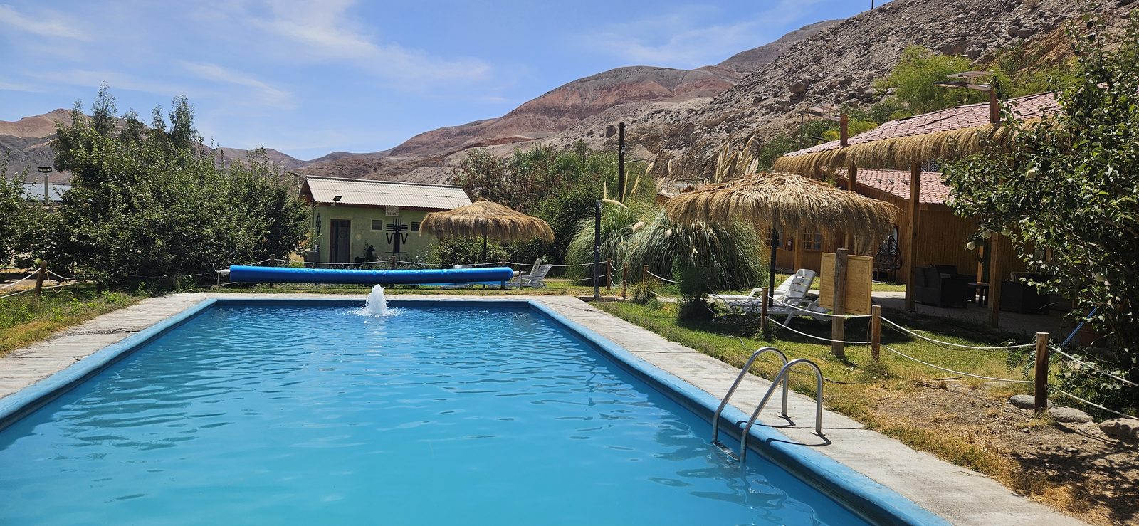 Piscina temperada del Camping El Mocheño con las montañas de la Quebrada de Tarapacá
