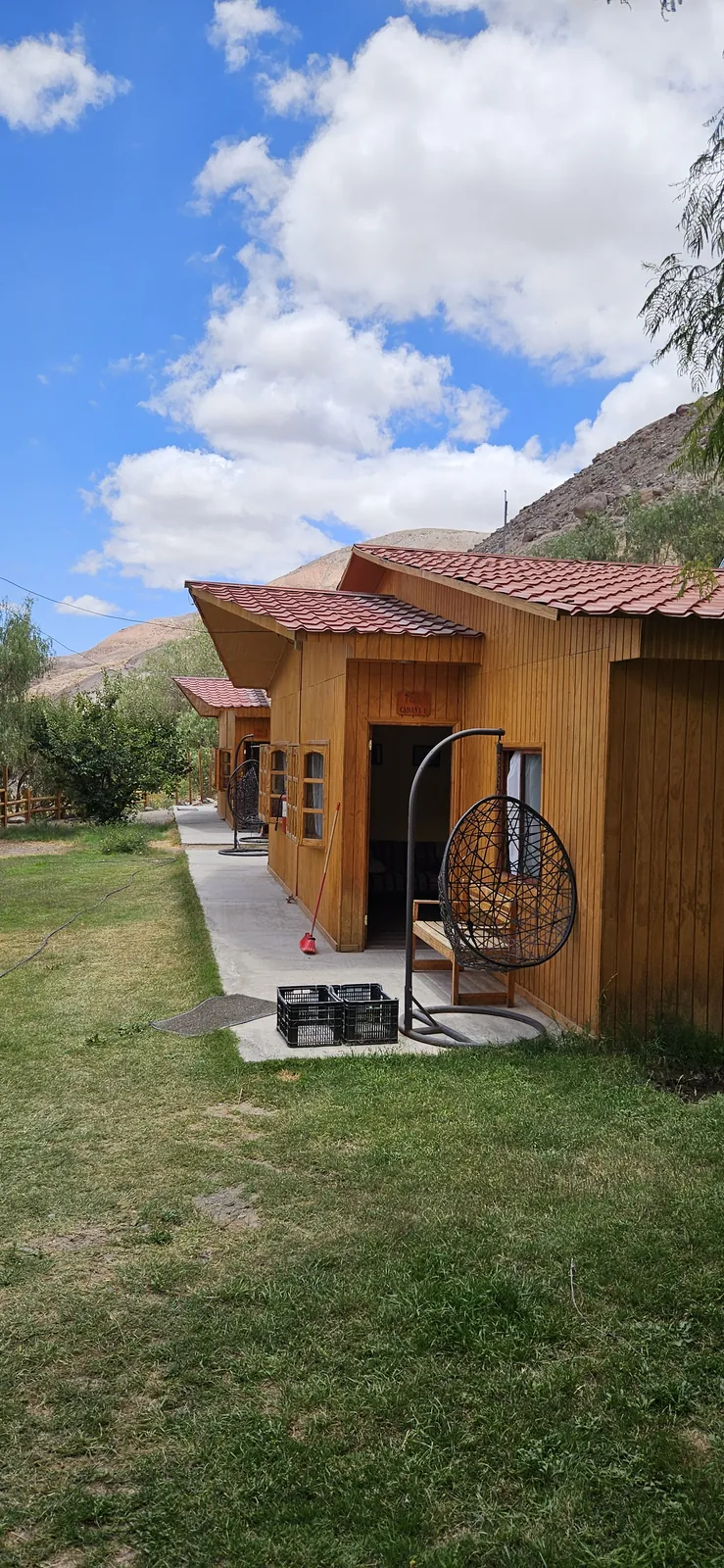 Terraza de cabaña con silla colgante